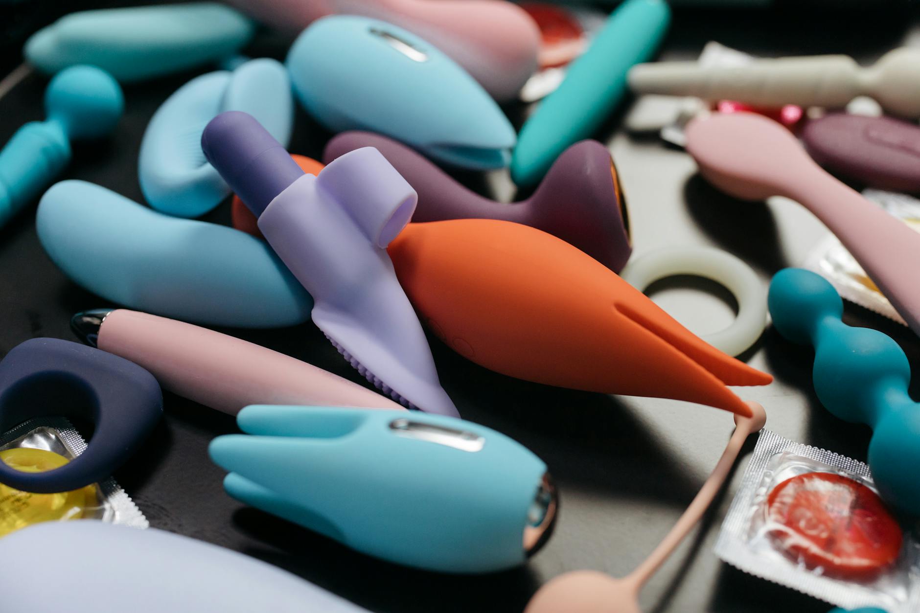 Close-up view of colorful vibrators and sex toys arranged together, representing modern couples pleasure tools.