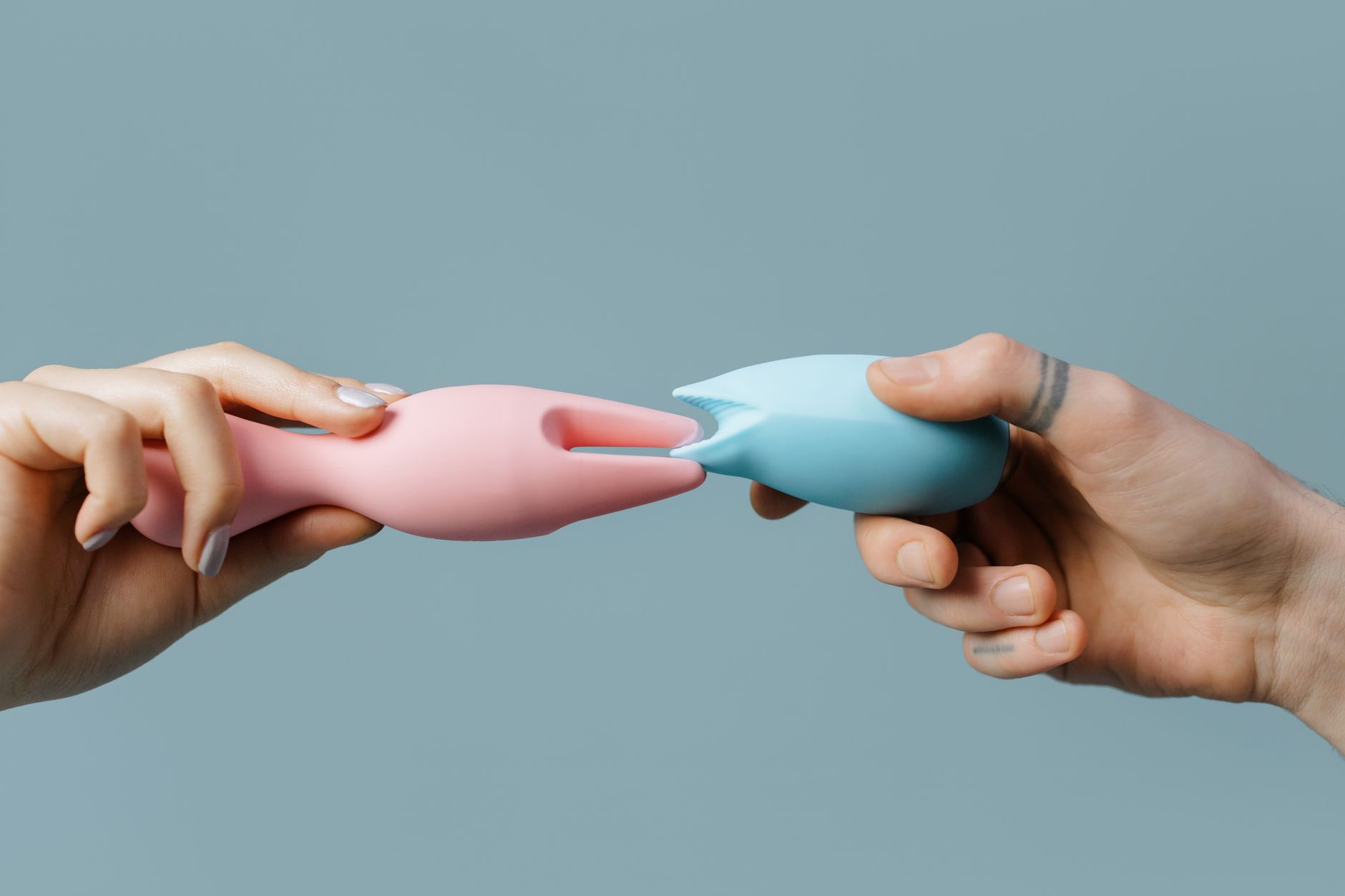 Hands holding colorful silicone intimate wellness toys
