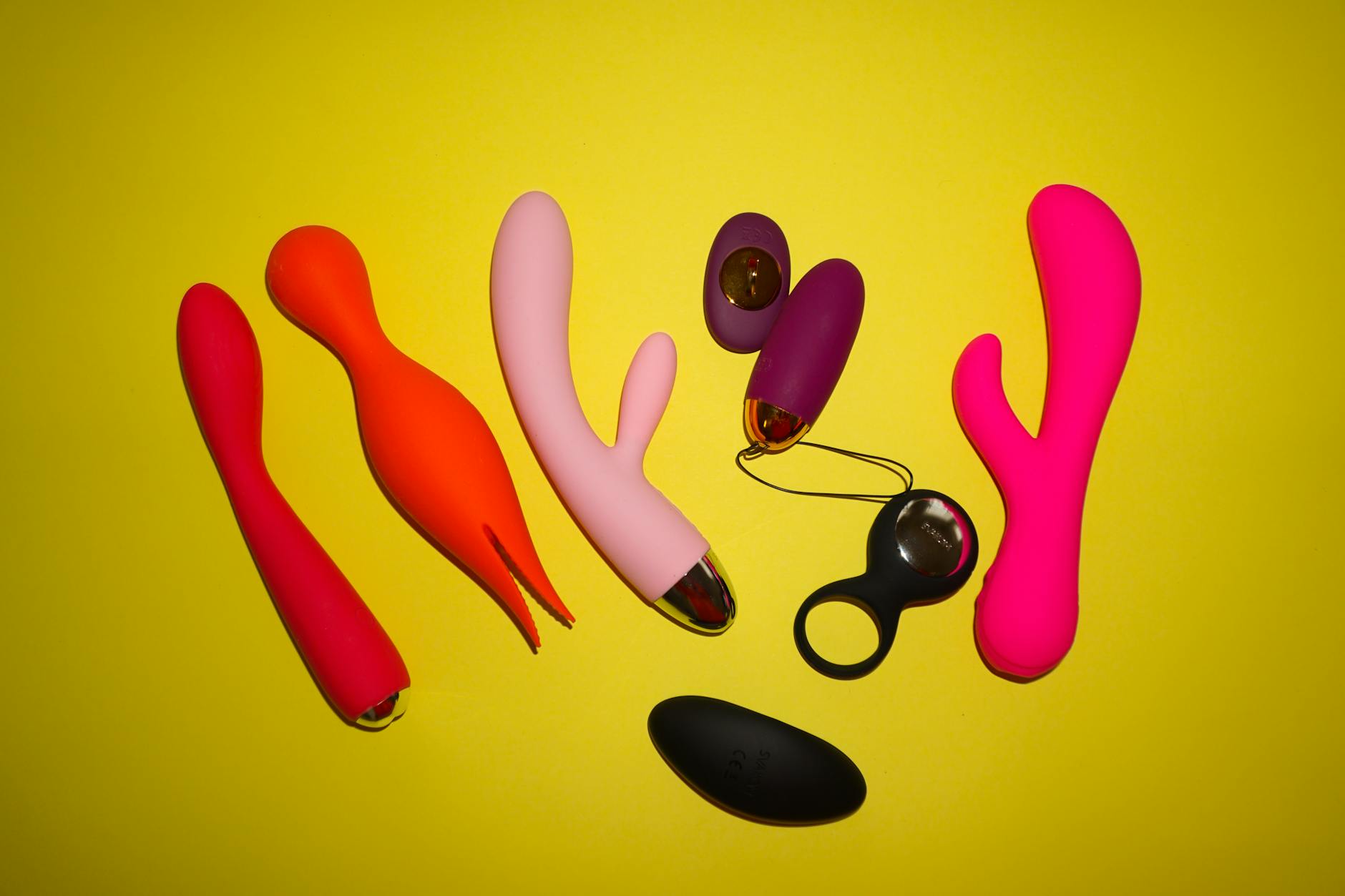 Hands holding a blue silicone vibrator against a knitted sweater